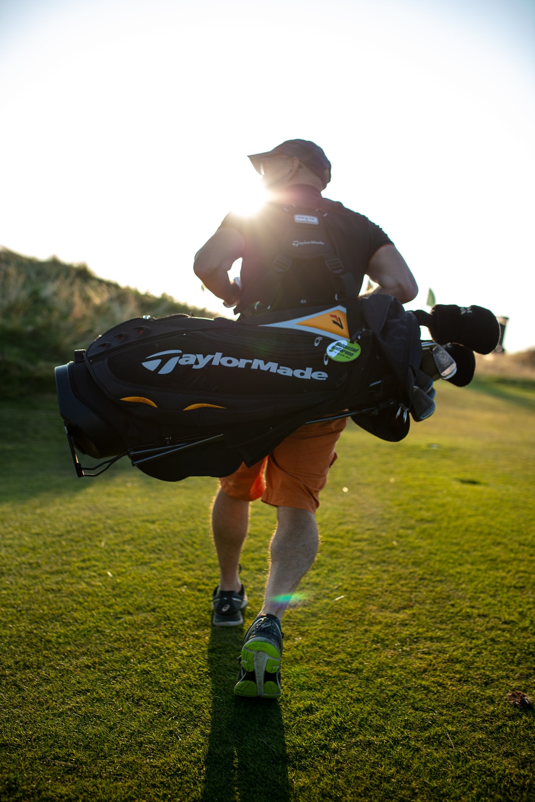 Golf Player carrying his golf-Kit, walking on the Golf court